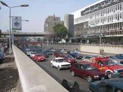 メトロでギザ駅到着。そして、こちらはピラミッド通り。
ご覧の通り、大渋滞です。

ここから、エアコンバスの357番を探すが、走っているのかは知っていないのか、よくわからなかった。
どれがエアコンバスだ？アラビア数字もよくわからん。

結局、この通りからギザ広場まで歩いた。ギザ広場はバスターミナルになっているので、何かしら手がかりはあるだろう。