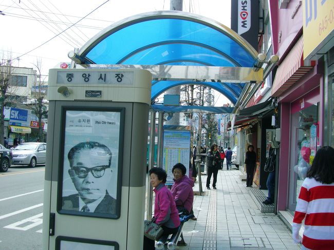 市内バスに乗り継いで２０数分後<br />「ﾀｳﾑﾝ ﾁｭﾝｱﾝｼｼﾞｬﾝ ｲﾐﾀﾞ」のｱﾅｳﾝｽ<br />　　は〜い！降りま〜す^^/<br /><br />←中央市場のバス停<br />写真の方は柳致環(ユ・チファン/1908‐67）<br />統営が生んだ詩人であり、教育者<br />釜山市内でバスに轢かれて６０歳で死去 <br /><br />