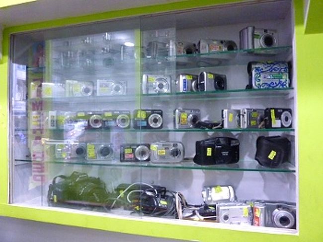 　通常は翌日仕上げですが、技術者は土曜休みのため、金曜土曜に来店する時は注意が必要です。指定された日に再び来店し、故障箇所が直っていれば、お金を払って終了です。「A to Z Camera Care」では、一応４ヶ月保証しており、同じ問題が起こった場合は修理に応じてもらえる(はずです)。<br /><br /><br />写真: 引き取りを待つカメラ