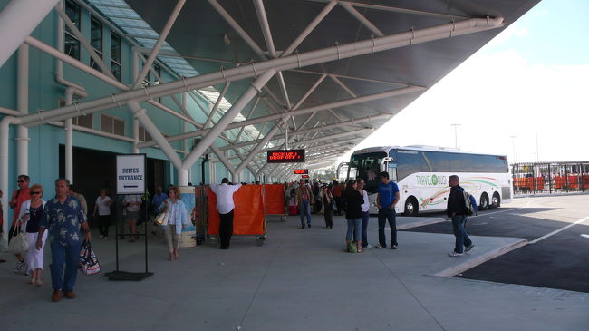 乗下船ターミナルに到着です。<br />手前側が乗船チェックイン箇所で、奥側が下船箇所です。<br />下船箇所には、荷物の受け取り箇所が有りますので、広い場所が必要です。<br /><br />バス下車場所でトランク等の大型荷物はポーターが受け取り船に積み込みます。<br />トランク等は部屋には早ければ午後２時ごろ配達されますが、到着が遅いと夕食後になる時が有りますので、少しでも早く港に到着してチェックインして下さい。<br /><br />バスは空港や市内ターミナル方面、ホテル送迎や貸し切りバスが待機しています。<br />バスは事前予約が必要なようです。<br />勿論タクシーも待機しています。