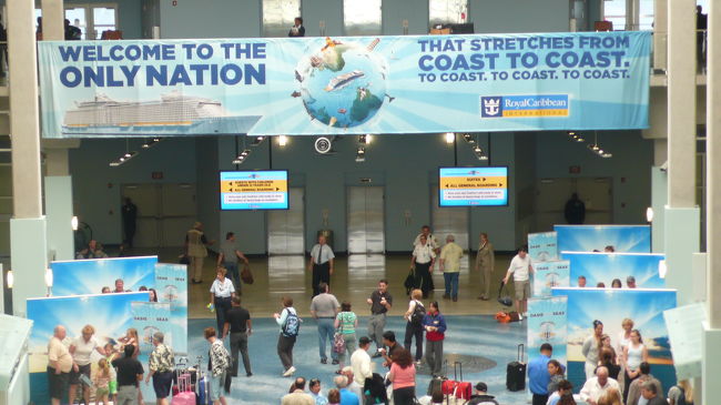 ２階から見た歓迎ボードと、有料販売用の写真撮影が行われています。写真の購入は自由です。<br />原則として全員必要で、シーパスカードにチェックが入ります。<br />これにより館内やオプショナルツアー時の撮影写真が、顔記憶装置により、一括して保管や検索が出来るシステムになっています。<br /><br />私は１０枚位は写されて保管されていましたが、今回は１枚も購入しませんでした。