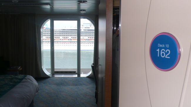 入り口の扉を開けると、大きなガラス戸の向こうに大型客船の姿、１０万トンクラスと思われます。<br /><br />カーニバル・クルーズ・ライン社のマークが見えます。<br />