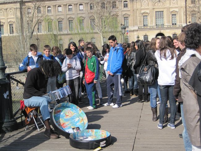 子供たちに囲まれる謎の打楽器を演奏している男性。