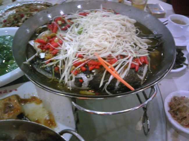 ただしメインのひとつ、魚のスープは辛くない。（辛くないって書きながら、写真には唐辛子が目につきますが。笑）<br />延びた面（麺）でラーメンのようにいただく。基本的に「川魚は臭くてマズイ」というリュウさんも、この料理は例外的にウマくてオススメなのだそうだ。