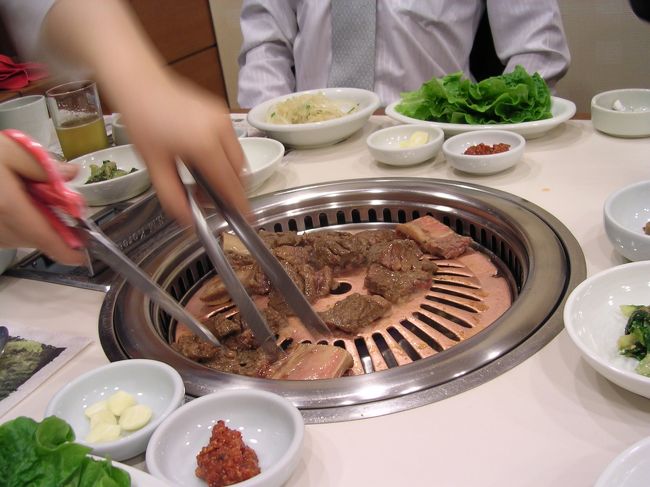 仕事も無事に終了し、取引先の方々とお楽しみの夕食へ。この日は前にも一度来たことのある焼肉専門店でのカルビパーティとなりました。<br />韓国式焼肉は、日本のよりもかなり分厚い肉に味がついてあって、食べるときに店員さんがハサミで切ってくれます。<br />それにコチジャンを箸でちょっとつけ、ニンニクをのっけてゴマの葉に巻いて食べるのですが、これはもうウマいの一言。<br />でも一緒の韓国人いわく「薄い肉を炭火で焼いてタレをつける日本式のほうが好き」とか！？