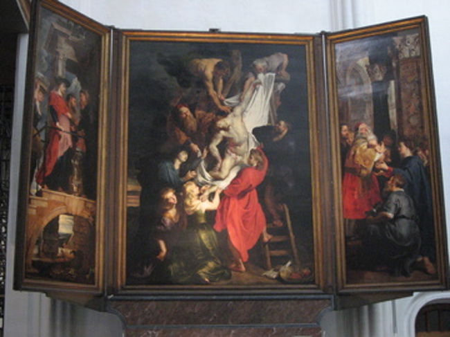 1614年 ルーベンス作「十字架降架」<br /><br />身ごもったマリアがいとこ姉妹に会っている画が向かって左側｡エルサレムの神殿で司祭長シメオンに幼児キリストを見せるマリアの画が向かって右側。<br />中央は一群の人々がキリストを十字架から下ろし、布で包もうとしている｡赤い衣の聖ヨハネ､女性は聖母マリア（上）､マグダラのマリアともう一人の女性｡<br /><br />クリスマスの夜、ネロとパトラッシュがこの画の前で息絶えた。<br /><br />この「十字架降架」と「十字架昇架」は、その昔、銀貨を払った人のみに公開されていたという。ネロは「ルーベンスは、貧しい人に画をみせたくないなんて思わなかったはずなのに」と悲しんでいたが、凍死する直前にこのふたつの画を見て「ああ神様、これで十分です」と言い天に召されていった。