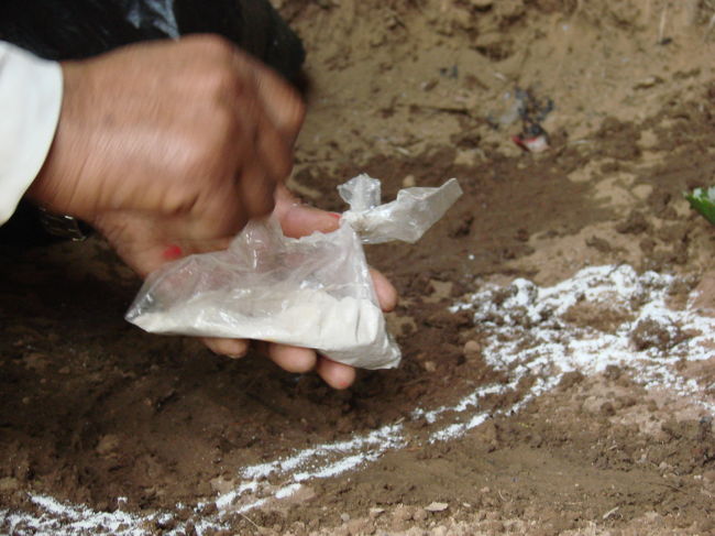 穴倉の手前で靴を脱ぎ入ってゆくと司祭らしき人が地面に白い粉で模様を書いている。