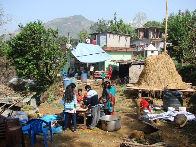 家に行ってみると横の広場では食事の準備がされている。