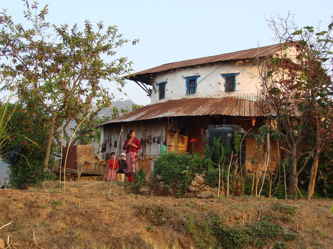 朝日を受けるキシナさんの家、サリーナがもう遊びに来ている、村の子供も朝が早い。