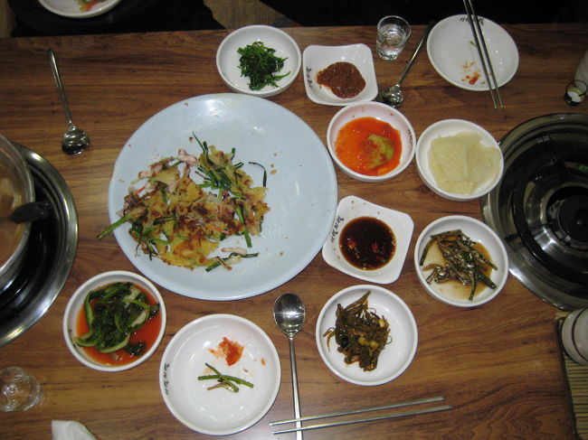 バスで旅客船ターミナル前の西湖市場に<br />戻って食堂に入りました。<br />私があまり辛いのが苦手と言ったら<br />タラのお鍋を辛くないようにと<br />頼んでくれました。<br />一緒に海鮮パジョンも注文しました。<br />割り勘で１人７０００Ｗ