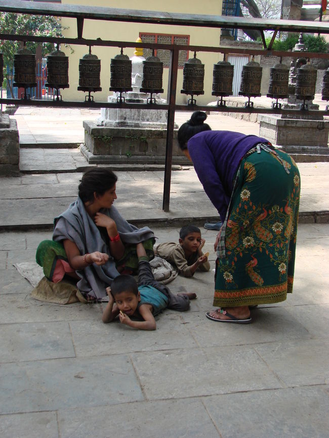 寺院へ上る石段の手前にいた子連れの物乞い。