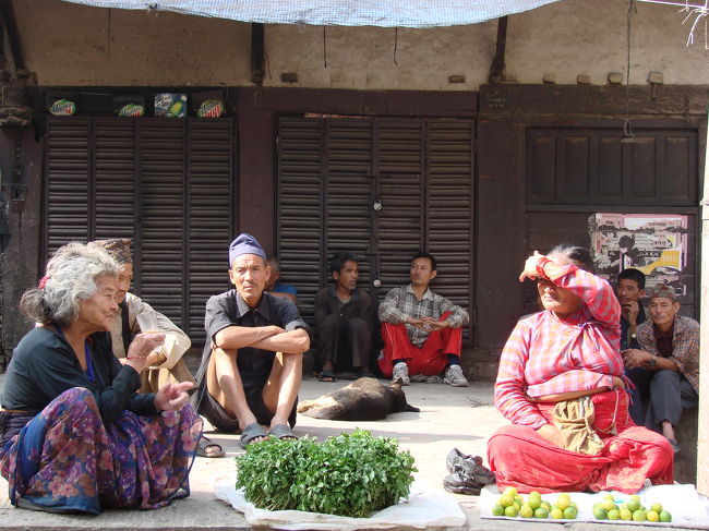 町の小さな広場で僅かばかりの野菜を売る人やたむろする人達。
