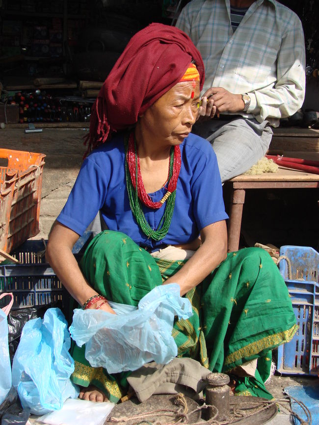 ビニール袋から何かを取り出そうとしている小母さん。