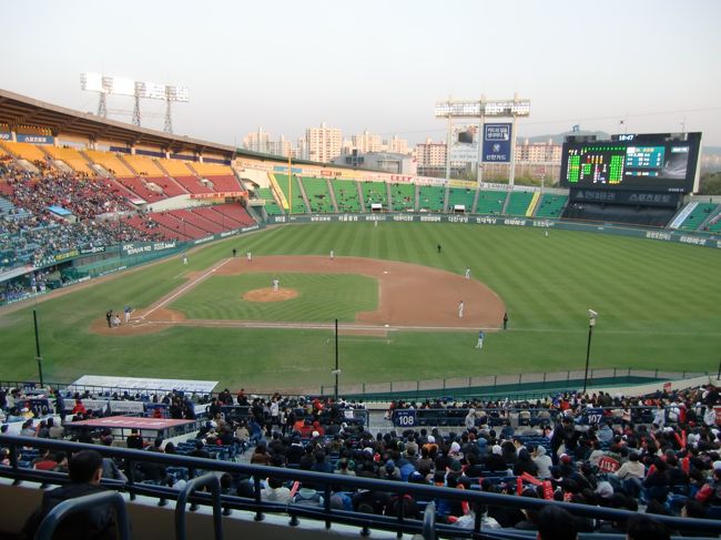 チェックイン後、早速行動開始。<br /><br />東大門歴史文化公園→地下鉄2号線→総合運動場（約35分）<br /><br />蚕室野球場で韓国野球の観戦です。<br />（LGツインズvsサムソンライオンズ）<br /><br />地下鉄を降りるとすぐ横に野球場があります。<br />チケット購入窓口の列に並び、チケットを購入。<br />韓国語はダメな私ですが、<br />「Yellow seat, LG Side, 1ticket please.」<br />と英語で言ってみたところ、すんなり買えました。