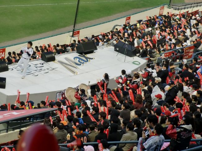と言っても、両チームの選手を誰も知りません。<br />いや、知っている選手もいるのかもしれませんが、スクリーンに映し出される選手名がハングルで、理解できません。<br /><br />でも、応援団の盛り上がりが物凄くて、これで十分楽しめます。<br />内野席にステージが設けられ、リーダーとチアリーダーのダンスに合わせて観客はスティックバルーンを叩くというやり方。選手1人1人のテーマソングがスピーカーから大音量で流され、スタンド全体がノリノリなんです。<br />（プレー中の選手には迷惑なような気もしますが・・・）<br /><br />甲子園の応援も凄いですが、この球場の応援も迫力がありました。