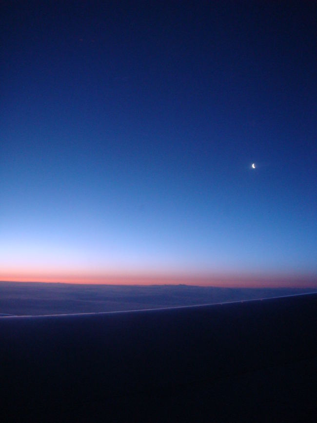 しばし飛行を続け、<br />ふと外を見ると美しい景色が。<br /><br />まもなく夜が明けます。