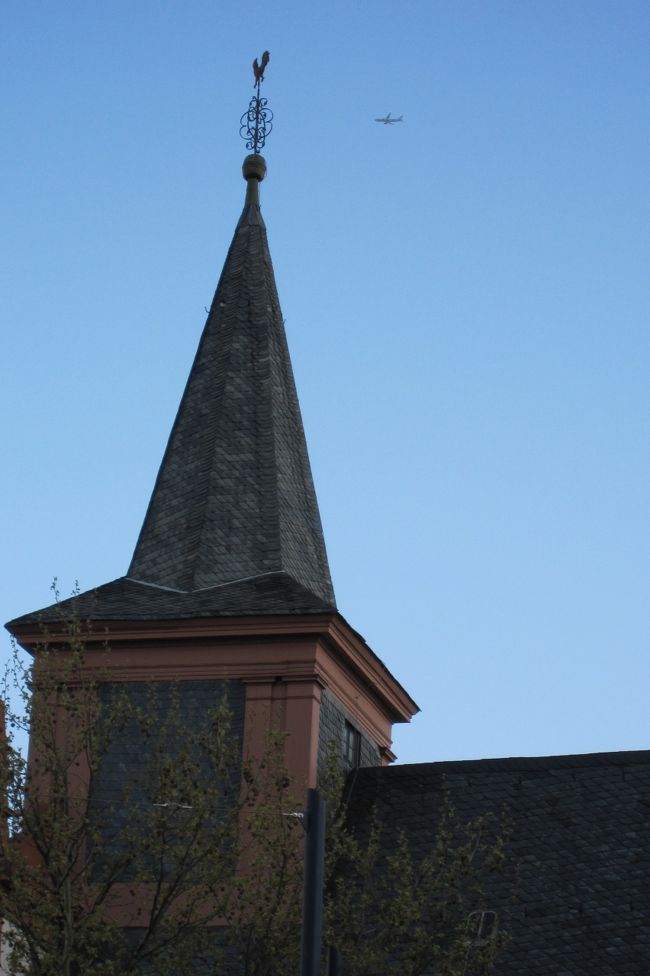 シャープな造りの教会の尖塔光景です。尖塔は逆光になりましたが、写真の狙いは、尖塔の最上部の屋根飾りの方向に向かう飛行機の姿でした。