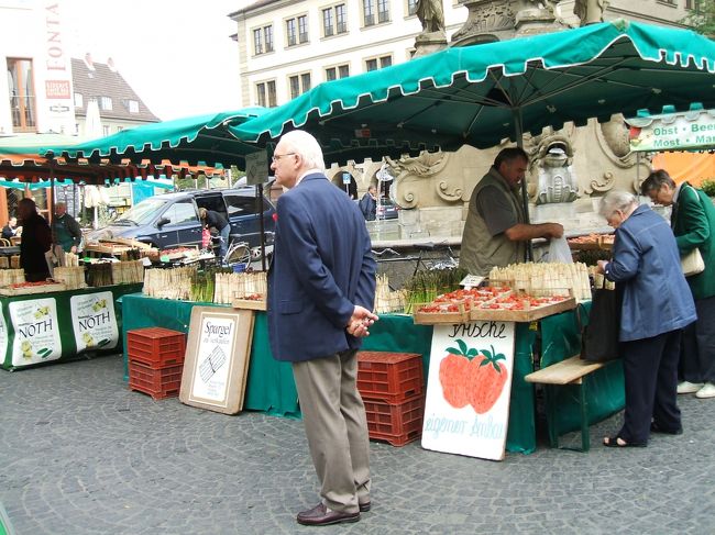 ヴュルツブルク：マルクト広場の市場。<br />張り切って履きなれない靴を履いてきたため早くも旅行３日目あたりから靴擦れをおこした。ここにきて我慢できなくなり靴を買い換えようと靴屋を探す。日本なら量販店などに安い靴が山積みされているがドイツでは見かけない。ようやく靴屋を見つけたが普通のウオーキングシューズみたいなのが５０ユーロ。当時１ユーロ１６５円ほどだったので高い買い物となった。以降旅行の終わりまでびっこ曳き曳きの旅となる。
