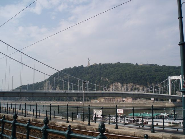 ７月２９日（土）<br />日程の都合でこの日はもうブダペストを離れウィーンへ行かなければなりません。<br />急ぎ足でブダペスト市内を観光します。<br />もっと休みがとれれば。。<br /><br />まずはドナウ川沿いを散策。<br />ブダペストはどういうわけかドナウ川沿い路面電車があり、歩道からでは線路が邪魔していい写真がとれません。<br />ちょっといまいち。。<br /><br />向こうに見えるのは、ハプスブルク家の美貌の皇后エリザベートの名を冠したエルジェーベト橋とゲッレールトの丘。<br /><br />丘の頂上には“しゅろの葉を掲げた女性像”が横を向いているのが見えます。<br />この像は、１９４５年にナチス・ドイツから街を開放したソ連軍の慰霊碑として建てられたそうです。 