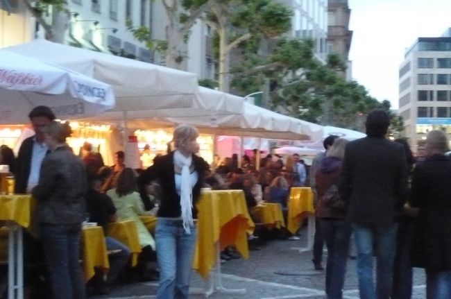 風呂上りでフランクフルトに戻り、そのままフレスガス通りの　ダス・ビルツハウスへ。　通りはテントの屋台が沢山、賑やかですが、　雨でーす。