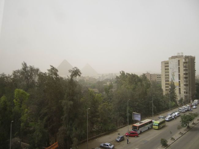こうして午後まで時間があいたので、とりあえずあまりの眠さとだるさに耐え切れず部屋で休むことに(笑)<br />ベッドに横になりながら、徐々に砂嵐がおさまってうっすらと見えてくるピラミッドを眺めているのは何気に贅沢な気分になりました！<br />まずは、第1ピラミッド・クフ王のピラミッドの斜面がうっすらと見えてきて、「あっちゃんあれじゃない？ピラミッド〜！」って興奮。<br />徐々に第2ピラミッドも見えてきて、曇り空みたいな感じではあるけど、完全に見えないよりはいいもんねって前向きに考えることにしました(笑)<br /><br />ピラミッドだけじゃなく、部屋からホテルの目の前を通っていた大通りを眺めているのもけっこうおもしろかった。<br />聞いてはいましたが、クラクションの音は半端なくうるさいし、しかも音楽風になっている。<br />いきなり道のど真ん中で数人が喧嘩を始めたり、頭の上に大きな荷物を乗せて、手を使わず運んでいる人を見たり（初めて見たので興奮しました！笑）外に出ずにも楽しめちゃいました♪<br />…そういえば、エジプトの方達は、夜中でも平気でたくさんの人が道を歩いていました。<br />普通に昼間のように！何をしてるんだろう(笑)