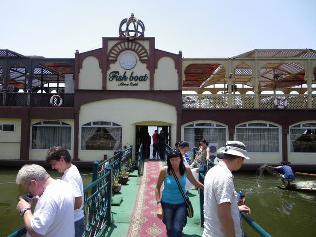 博物館の見学を終えて、タクシーに戻るとサーコが外で知り合いと座りながらタバコを吸っておしゃべりしてました。<br />そして、あっちゃんのことを「俺のワイフだよ」って紹介してた(笑)　しつこい冗談だけど、これも日本で言うオヤジギャグみたいなものなのかなぁ〜！<br /><br />すっかりお昼の時間がすぎていたので、ナイル川のほとりに建つ、船のような形のレストランに連れてってもらいました。<br />景色も雰囲気もとてもよかった♪…でも、食べるものがないバイキングでした＞＜<br />というのも、どうしてもエジプトに行く前の知識で、お腹を壊すっていうイメージがあったので、あまり積極的に食べられず、とりあえずパンを食べようと思ったのですが、サーコが「全然取ってないじゃん！」といって、肉やらごはんやらマカロニやらをたくさん乗せてくれたので、少しだけ食べました。