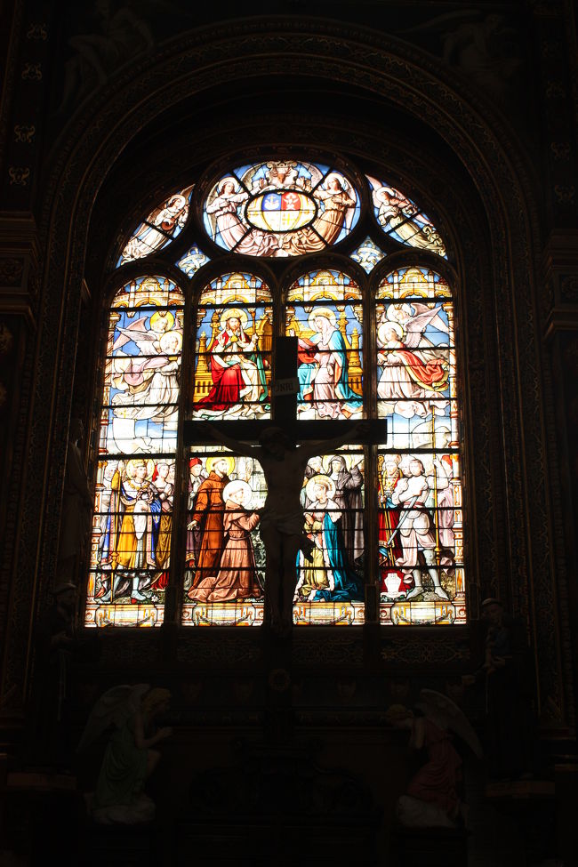 キリストの像がステンドグラスの前にあります