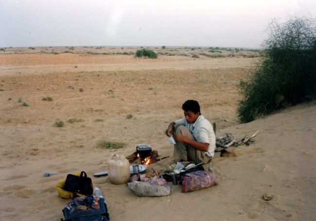 泉で水のタンクに茶色く濁った水をぎりぎりまで詰め込む間、ラクダ達も背中のタンクにガブガブ水を溜め込んだ。<br />これでどうにか水の心配はなくなった。<br /><br />その後、なんか一回り大きくなった様なコブに揺られ、太陽が沈む頃、やっとガイドが「あそこで寝よう」と言い出した。<br /><br />指差す先にあるのは、どう見てもただの砂山だ。<br />あれなら、ここまで来る間、いくらでも似たような場所があったはずなのだが・・・<br />まぁ、とにかく夜になる前にキャンプできるのはありがたい。<br />ここは何も言わないでおこう。<br /><br />チップと水の事しか知らないと思っていたガイドの小僧が、思いの他素早く夕食の用意を始めた。<br />砂の上に、簡単なかまどを作り、器用に火を起こすと、フライパンでカレーを炒めだす。<br />あっという間に飯の時間がきた。<br /><br />あれほど食いなれたカレーでも、たとえ砂が混じっていようとも、これほどのオープンスペースで食うのは美味い！<br />