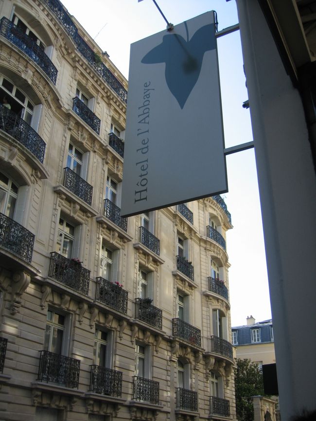 タクシーは路地に入り、うねうね進んでいく。<br /><br />パリの地図はかなり読み込んできたつもり、今どの辺りか見当つけようとするが、分からない。<br />ホテルが近いことは分かるけど・・・。<br /><br />しばらくうねうねして、「運ちゃん、距離かせいでるんじゃないだろうね？」と少しばかり怪しみはじめた頃(笑)、ホテルのトレードマークであるリーフの模様の看板が目に入った。<br /><br />さあ、支払いを。<br />チップと荷物分をプラスしてこれぐらいかな？と夫と道中ひそひそ相談していたけど(笑)、運転手さん自ら、「荷物分入れて○○ユーロね」と提示。<br />ならば、とそれに少しチップを足した金額を渡す。<br />あっさり商談成立。<br />運ちゃんは荷物を降ろしてくれて、笑顔で去っていった。<br />ちなみに、シャルルドゴールからパリ市内までのタクシー運賃相場は５０ユーロぐらいとのこと。<br />私たちは荷物分入れて５６ユーロと言われたので、チップ入れてたしか６０ユーロ渡したような気が。<br /><br />さて・・・今回利用したホテルはサンジェルマン地区の<br />「Hotel de l'Abbaye Saint Germain 」（ホテル　ドゥラベイ　サンジェルマン）。<br />サンジェルマン大通りの南側の地区。<br />レンヌ大通りから一本入ったカセット通りにある、プチホテルです。<br /><br />ＨＰで見たままの鉄門をくぐって玄関へ。<br />石畳なのでスーツケースが押しにくい。<br />もたもたしていると、ポーターさんが出てきて運んでくれた。<br />玄関を入ると左手すぐにフロントが。<br />「ボンジュール♪」<br />ああ、ちょっと緊張。<br />夫が旅のフランス語で必死に覚えた片言で名乗る(笑)。<br />でも、スタッフさんはぺらぺら〜と英語で返してくれた(笑)。<br />英語ネイティブですか？と思うほどに英語ぺらぺらだ。すごい。<br /><br />いわゆる宿帳に記入するように言われたのだけど、緊張してがちがちになっている夫は、住所欄でつまづいた(笑)。　たしかに、英語で住所を書く想定をしていないと、書く順番とか一瞬とまどう。　私が代わって適当に（いや、一応ちゃんと書いたが(笑)）書く。<br />海外で宿泊するのに慣れていない方は、住所の英語表記を確認しておいたほうがよろしいかと・・・。<br /><br />この一件で夫が少し気分的に固まってしまったようだ(笑)・・・。<br /><br /><br /><br /><br /><br /><br />