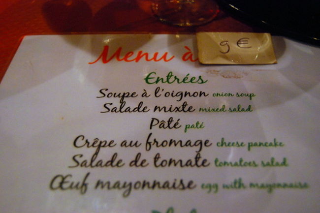 テーブルに置かれたメニュー。<br />12ユーロが9ユーロと書き換えて貼られています。<br /><br />しかし、どの料理も9ユーロほどの価値はなく…（笑）<br />クリームソースのパスタなど、クリームですらなく、本当にシャバシャバで、ミルクの味もせず、恐ろしく経済的な比率で粉ミルクを溶いたのではないかと思われる1品でありました。<br />麺もクタクタ（※パリのパスタでアルデンテは稀なのですが、それにしても…）というより、麺が切れ切れでした。<br />ここまで不味い料理もそうそう出会えない！…と、不愉快を通り越してだんだん楽しくなってきた私たち。<br />お店を出る頃にはお腹の皮がよじれるほど笑い、素晴らしい話のネタの一つとなりました。<br /><br />※後日談として、翌日モン・サン・ミシェルに行くバスツアーの中で添乗員さんにその話をして「あの賑やかさ、パリにして飲食店の客引きのエリア、あれは一体なんだったんでしょう？」と聞いてみると、アメリカ人御用達エリアなんだとか、何故か納得（笑）<br />
