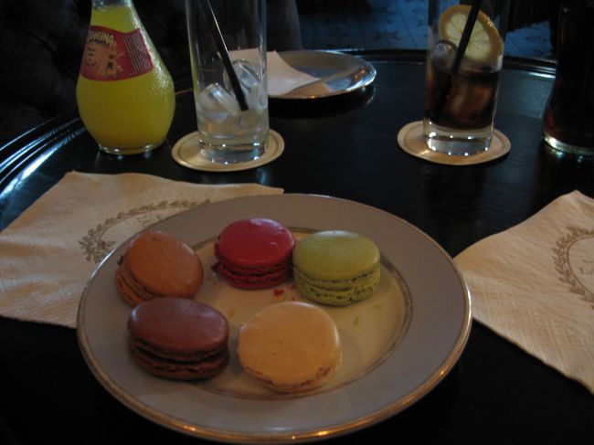 すると、後から入ってきたお客さんが奥の階段の方へ進んでいく。<br />あっちがサロンなのかな、ついていってみる。<br />ここでテイクアウトにしておけばよかったものを、サロンに入ってしまったがゆえに失敗することとなるのだが・・・。<br /><br />２階へ上がるとギャルソンがいて「２名？」と訊いてきた。<br />奥のサロンへ案内され、入口近くの空いていた席へ座る。<br />サロン内は薄暗めの照明にくすんだブルーグレイの壁、クラシックな雰囲気の調度でまとめられ、なんとなく神戸の異人館を思い出した。<br />マダムの二人連れ、旅行者ぽい男女グループ、奥には日本人らしき中年男女のグループも・・・広くないサロンはほぼ満席だ。<br /><br />メニューを渡される。<br />分厚い。<br />飲み物からマカロン、デザートから軽食まであるようだ。<br />私は、ガイドブックで目にしていたマカロンをデコレーションしたようなケーキが食べたかったのだけれど、どれがそれなのかさっぱり分からない。<br />しまった、品名をチェックしておけばよかった。<br />メニューには一応英語表記もあるのだが、初めて入ったパリのサロンで気持ちがてんぱってしまい、集中できない。<br />結局、かんで「これかな？」と思うのを適当に注文してみた。<br />夫もホテルで意気消沈していた上に雰囲気にのまれてしまったようで、固まっている(笑)。<br /><br />心配はメニューだけではなく、お会計の仕方もいまいち分からない。<br />一応、本で勉強してきてはいたけど、いざとなると詳しいその手順が頭から抜けてしまっている。<br />周りのお客さんの動きを観察する。　全然、雰囲気を楽しむどころではない(笑)。<br /><br />けっこうな時間待って、やっと頼んだものが来た<br />（なぜか、後からオーダーしたはずのお客の方に次々先に運ばれてきていた。　そんな手間のかかる物は注文しなかったはずなのに・・・ちょっと気分が悪かった）。<br />私の当てずっぽう注文はやはり間違っていたようで、食べたかったケーキタイプの物ではなく、普通のマカロンが運ばれてきた（残念！）。<br />夫が頼んだ４種セットと合わせて、５種のマカロン。<br />これを半分こした。<br /><br />そうはいっても、マカロンはさすがにおいしい♪<br />さくっ、というかしゃくっとした生地が好みだった。<br />フレーバーも、くどくなくそれでいて素材の香りはしっかりと広がり、さすが有名なだけはある。<br /><br />会計もなんとかこなせた。<br />商品と一緒にレシートを持ってくるので、小皿にお金を置いておくとギャルソンが取っていき、お釣りをまた皿に返しにくる。<br />そのお釣りから、チップを置いていけばよいようだ。<br />今回は商品を持ってくる順番に納得がいかなかったので、チップは置かずに出ようかと思ったけれど、やはり弱気になって少しだけ置いていった。<br /><br /><br />マカロンを売る売り場と背中合わすようにして、オリジナル雑貨の売り場があった。<br />ここのマカロンが大きくプリントされたトートバックをお土産に買おうと思っていたのだけど、欲しかった柄のものが見当たらない。<br />しかたがないので、店を出る。<br /><br /><br /><br />