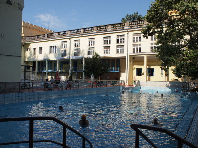 着替える場所がよく分からない…とまごまごしていると、先ほどのおばちゃんが２階へ行けばいいよ。と。<br />ここはロッカーは男女兼用のようです。<br />(鍵のかかる更衣スペースがあります)<br /><br />施錠はセーチェニと同じ、Perfect Systemでした。慣れたものです。<br /><br /><br />水着に着替えて外に出てみると、プールで泳いでいる方々がたくさん。<br />ここは皆水泳帽してました。着用必須なのかもしれません。<br /><br />セーチェニの件からすると、プール以外に内風呂があるはず…。<br />しばらく探検してみると、ぐるっと回った反対側の建物がそうでした！<br /><br />（写真では左奥の方…写ってませんが）<br /><br />どうやら、来る時に見かけた入り口は温泉用の出入口の模様です。<br />そこからどうやって入るのかは謎ですが…。<br /><br />ここは40度の浴槽がありました。<br />でも不人気。こちらのヒトには熱すぎるのでしょうか。<br />36度の浴槽は大人気。セーチェニと違って(時間が早いからかもしれませんが)じいさまばあさまが多かったです。<br />