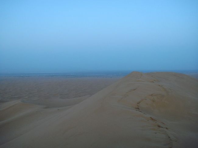早朝必死で登ったドデカイ砂丘の上から日の出を待つ。