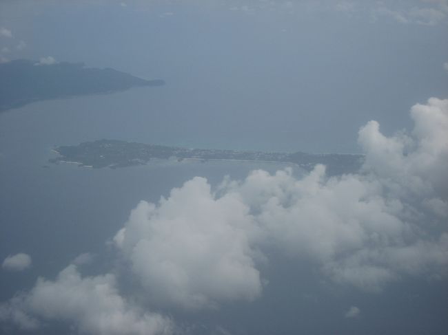 成田から4時間弱でマニラ着。国内線への乗り換え時間1時間半。<br />入国審査にかなり時間をとられ、さらに預けている荷物を一度受け取ってチェックインし直さなければならないという事で、国内線への乗り換えはかなりダッシュになってしまった。あまりに荷物が出て来ないので、近くにいた係の人に尋ねたところ、私のbaggage claimを見て、荷物が出て来たところで何らかタグを付けてくれ、そのまま国内線へ行くよう言われた。そこでペソに換金、国内線空港使用料を支払い、なんとかカリボ行きのフライトに間に合った。<br /><br />今回の目的地、ボラカイ島に行くには2通りの行き方がある。<br />ひとつはマニラからカティクラン空港まで飛行機、そこから数分の車移動でカティクラン港、そこからボートで15分でボラカイ島。<br />もうひとつは、マニラからカリボ空港まで飛行機、そこから90分の車移動でカティクラン港、あとは同上である。<br />カティクラン空港はフライトが天候に左右されやすいということで、雨期である今回は確実な方を選んだ。<br /><br />画像は機上からのボラカイ島である。