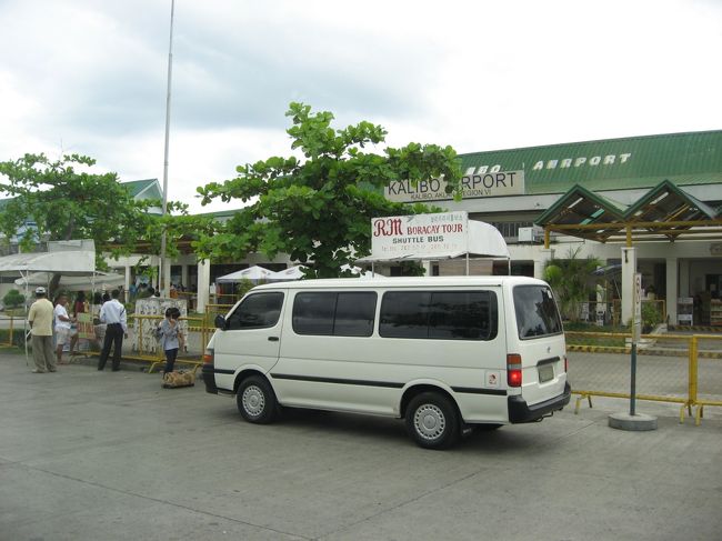 カリボ空港に降り立つと、お揃いのシャツを来た職員の人達が、「Do you need a porter?」と近づいて来る。ん？職員じゃなく、空港内出入り許可を得ているポーター業者らしい。とりあえず断って、トイレ・・・早くもここから便座がない。。。職員の女性はどうしているのだろう。<br /><br />頼んでおいたピックアップバス（画像）に乗り込み、90分のドライブ。しんどいかと思っていたが、爆睡していたらあっという間だった。