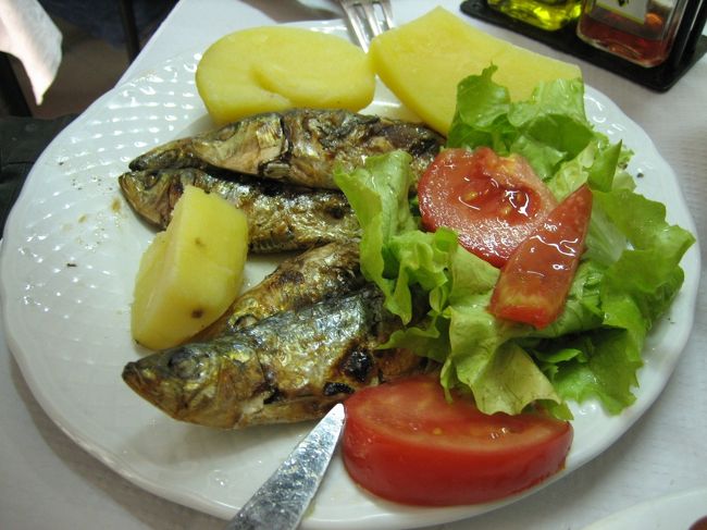 イワシの塩焼きです。これもさっきのイカもハーフポーションですが、二人で十分な量でした。<br />これにヴィーニョヴェルデという若いブドウを使った微炭酸の白ワインをハーフボトル頼んで、二人分合計で20ユーロ以下でした。<br />あらゆる面で大満足の昼食になりました。<br />