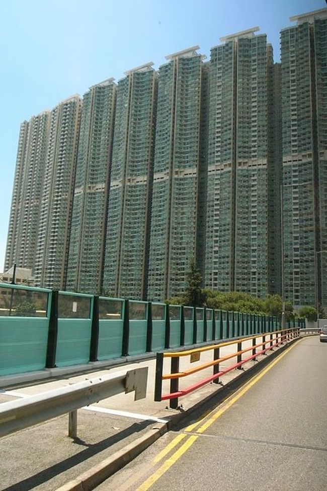 こんなマンションあったっけ？というほど、<br />超高層・壁そっくりな巨大マンションが<br />見えました。<br /><br />空港から九龍、海底道を通って上環・中環まで<br />スムーズだったのに、急に湾仔からバスが<br />止まったり進んだり…。<br /><br />実は旅行日程を決めて予約するまで、<br />今日が香港での祝日って知らなかったんです。<br /><br />香港返還記念日で、銅鑼湾から中環方面へ<br />デモ行進とかがあるみたい。<br /><br />湾仔でも一部の車線を閉鎖していたりして、<br />車も混んでました。