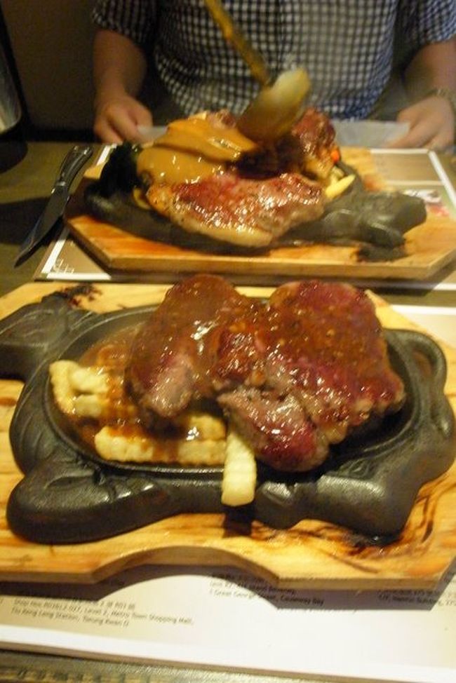 ステーキが到着！<br />びっくりするサイズと量！<br /><br />2種類のソースが選べ、<br />目の前でペッパーソース、<br />旦那さんはガーリックソースをかけてもらう。<br /><br />テーブルナプキンを囲いにして、<br />自分で油はねを防ぐのが、こっちのやり方。