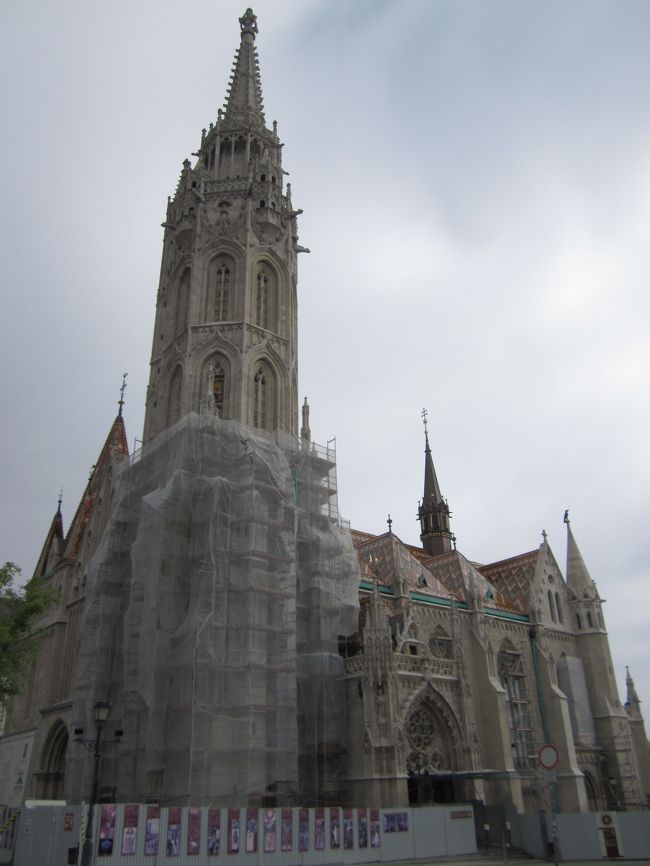 マーチャーシュ教会<br /><br />補修中で正面左半分が覆われていた。<br />入り口は９時から開くので、まだ早い時間だし、周囲を散歩する。