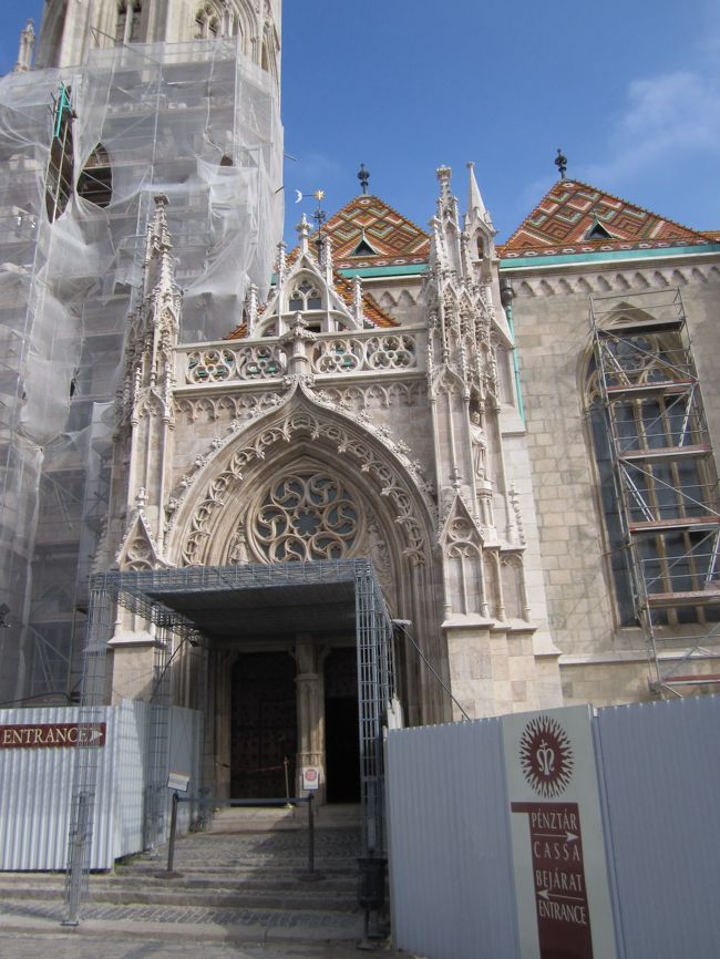 マーチャーシュ教会の入り口<br /><br />見学可能時間になり、覆われてない入り口から入る。<br />入場券は教会入り口から見て、広場の向かいの建物で購入。<br />教会750Ft。漁夫の砦500Ft。