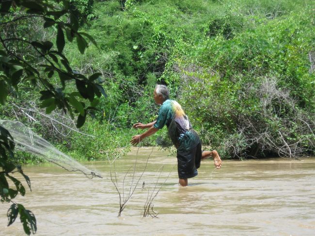 元来た吊り橋を渡り、ちょっと自転車を走らせる。<br /><br />漁師さんが網を整えていた。<br /><br />「漁を見たい」とジェスチャーで伝えると、<br /><br />準備を整えた後「こっち来い」の合図。<br /><br />何度も通っているらしく、草の生えてない踏み固められた道を進み、左右から木々が覆いかぶさるトンネルを抜けて、流れの穏やかな水辺に出た。<br /><br />そこで一網、前に少し進んで一網打ちながら川の真ん中まで行った。<br />