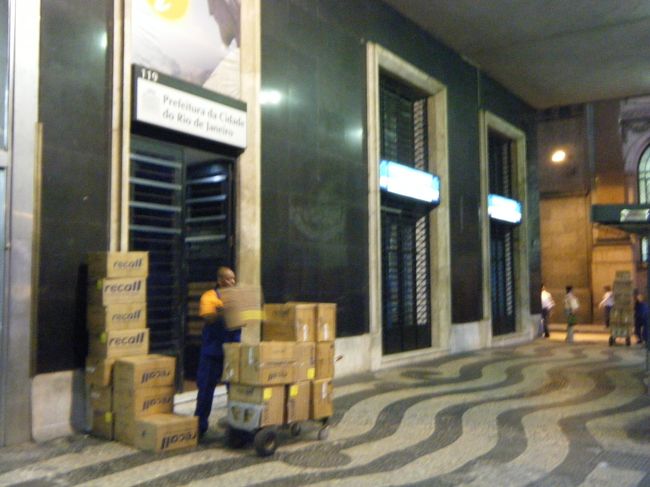 Pio X広場119の観光案内書<br /><br />このおじさんが荷物を出している建物が観光案内書です。なかなかみつかりませんね。中にはおじいさんとお兄さんがいて、Rioの地図とパンフレットをくれました。パンフレットの最後のページにバスの路線の表があります。もちろんお兄さんは英語OKです。もしおじさんしかいなかったら???