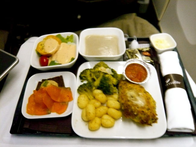 さあお食事の時間です！<br />サーモンムースに<br />マッシュルームのクリームスープ、<br />シーザーサラダに<br />メインは鶏肉のパルメザンクラスト<br />ニョッキとブロッコリー添え。<br />豪華だけど…あれ？ あんましおいしくない！<br />エールフランスのエコノミーのほうが<br />おいしいかも！ 残念すぎます！