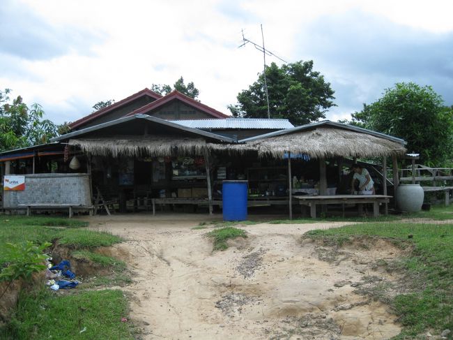 ここがオッチャンが連れてきてくれた（バス）待合所。<br /><br /><br />疲れたので、豆乳を買う。１パック3,000K<br /><br />店のおばちゃんはにこりともせず、無愛想だった。まあ、これがラオスの国民性だろう。<br /><br /><br />縁側？に腰掛け、少し飲むと、バスがやって来るのが見えた！<br /><br />オバちゃんが「○×△！」と叫ぶ。…きっと「手を降れ」とでも言っているんだろう…<br /><br />一歩前に出て、大きく手を降った…が撃沈。ものすごいスピードで30m先の目の前の道路を通過していった。…ガックリ。<br /><br /><br />しばらくして、大型ダンプが２台連なってやって来た。<br /><br />オバちゃんがまたもや「○×△！！！」と叫ぶ！　…へ？あれってバスじゃないだろ？？？まあいいや…<br /><br />今度は、リュックを肩にかけ、道路際まで走って行き、手を降った。<br /><br />１台目が通過し、２台目が停まってくれた。<br /><br />「パクセ？？？」と聞くと、<br /><br />頷きながら「パクセ」と答えた。ヤッター！<br /><br />有り金を全部…と言っても30,000Kしかないが…渡し、トラックに乗り込んだ。<br /><br /><br />運転手はそのお金でタバコを買った。<br /><br />ギアを切り替え出発した。<br /><br />オバちゃんに手を振ると、振り返してくれた。ありがとう。<br />