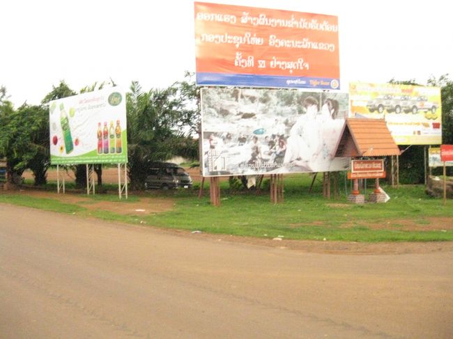 トラックはパクセに到着。カメラに付いている時計を見ると４時を過ぎていた。<br /><br />ここで降りろとのこと。<br /><br />「ありがとう」と礼を言い、クルマから降りる。<br /><br /><br />…のはいいものの、自分が何処にいるか分からない。…<br /><br />看板の向かいに、自転車・バイクの修理屋があった。<br /><br />従業員か主人かわからないが男の人が相手をしてくれた。<br /><br />彼は英語が話せた。<br />