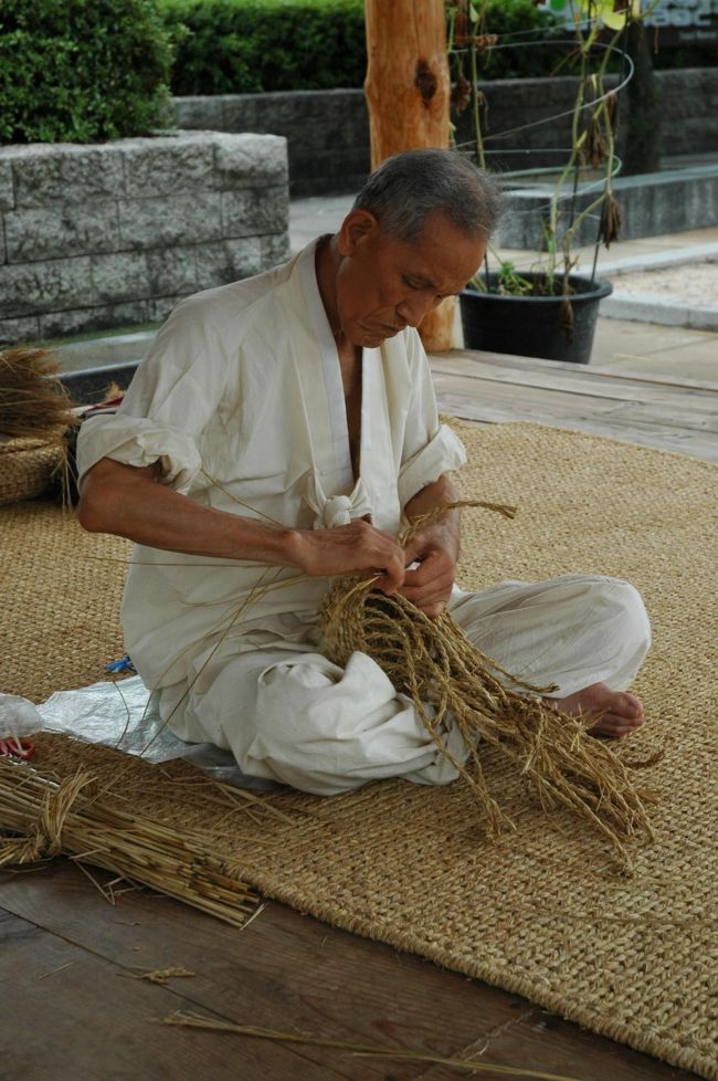 編み籠をつくっているおじいさん。看板があって、どうやら人間文化財のような方らしい。<br />昔、ウチの祖父も作っていたのを思い出しました。そういえば小学校の授業でワラジを作ったこともあった！（←年がバレる）