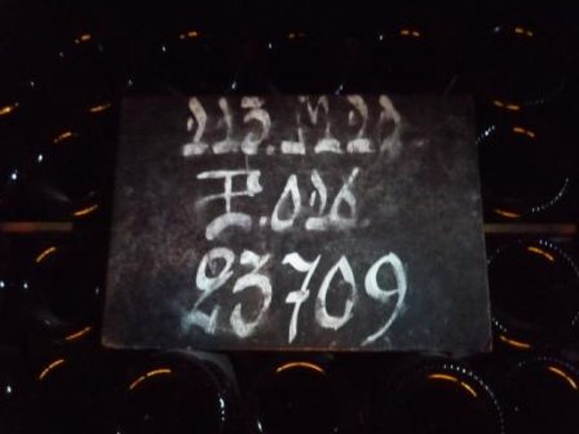 瓶達の前に置いてあるこの看板、下の“２３７０９”は本数を示していて、上の数字とアルファベットはシャンパン作りに携わる者達のみぞ知る暗号になってるんだって。<br />