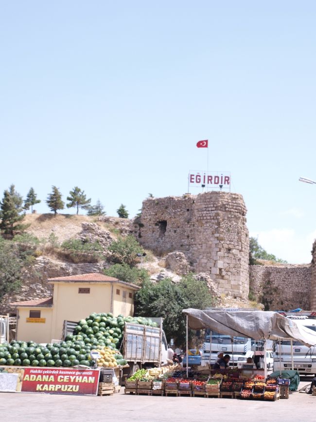 さて、バスターミナル近くに戻ってきました。<br /><br />スイカの量がすごいです(笑)<br />奥の砦跡がある丘には歩いて登れます。