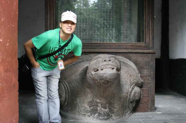 唐碑。<br />諸葛孔明を褒め称えた唐代の石碑。<br />三絶碑と言われ、文章、彫刻、筆跡がとても素晴らしいという意味だそうです。<br /><br />その下の亀。<br />昔、この辺りの川（岷江）で悪さをし、度々洪水を起こした亀を閉じ込めて暴れないようにしているそうです。ガイドさんが亀の真似をしています。<br />