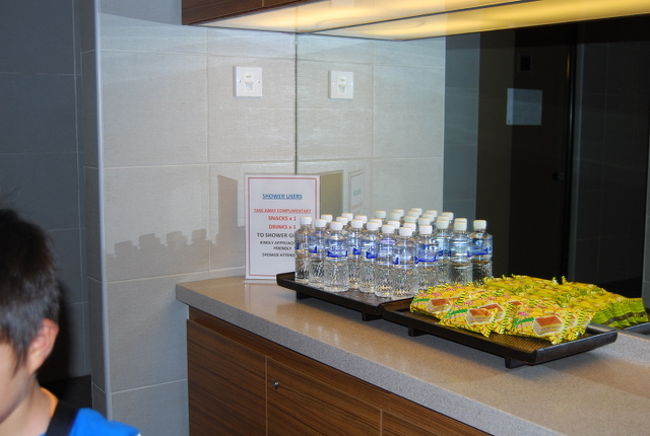 そのむかえには、お土産の、水のペットボトルとスナックがおいてあり、これを一つずつお持ち帰りくださいとのことです。<br />このラウンジ前に置いてあるメニュー表には、<br />シャワーには、one drink &amp; one snack　incl. とありますが<br />シャワー後に、ラウンジでのんびりジュースや軽食なんてのは御法度です。<br />この場合のdrinkとは、この水のペットボトルのことです。<br /><br />シャワーを出た後は、免税店をまわったり、インフォメーションでWIFIのパスワードを発行してもらって（利用は無料です）Ipodでネットをして時間をつぶしていました。apple製品は無料の充電器もありますね。<br />ここは携帯の充電ステーションだったのですが、日本のFOMAなどは対応していませんでした。<br /><br />その後、GATEがOPENしたのでいくと、なにやら入り口付近で焦っている修学旅行生が、<br /><br />なんとパスポートを落としたと。<br /><br />近くにいた、空港の掃除スタッフがこれじゃないかと持ってきてくれて、無事、事なきを得たようです。<br /><br />さて、今回の旅行もおしまい。<br /><br />帰りのSQは若干空席があったので、離陸後さっそく席を移り、親子共々横になりながら寝ることができました。めでたしめでたし。